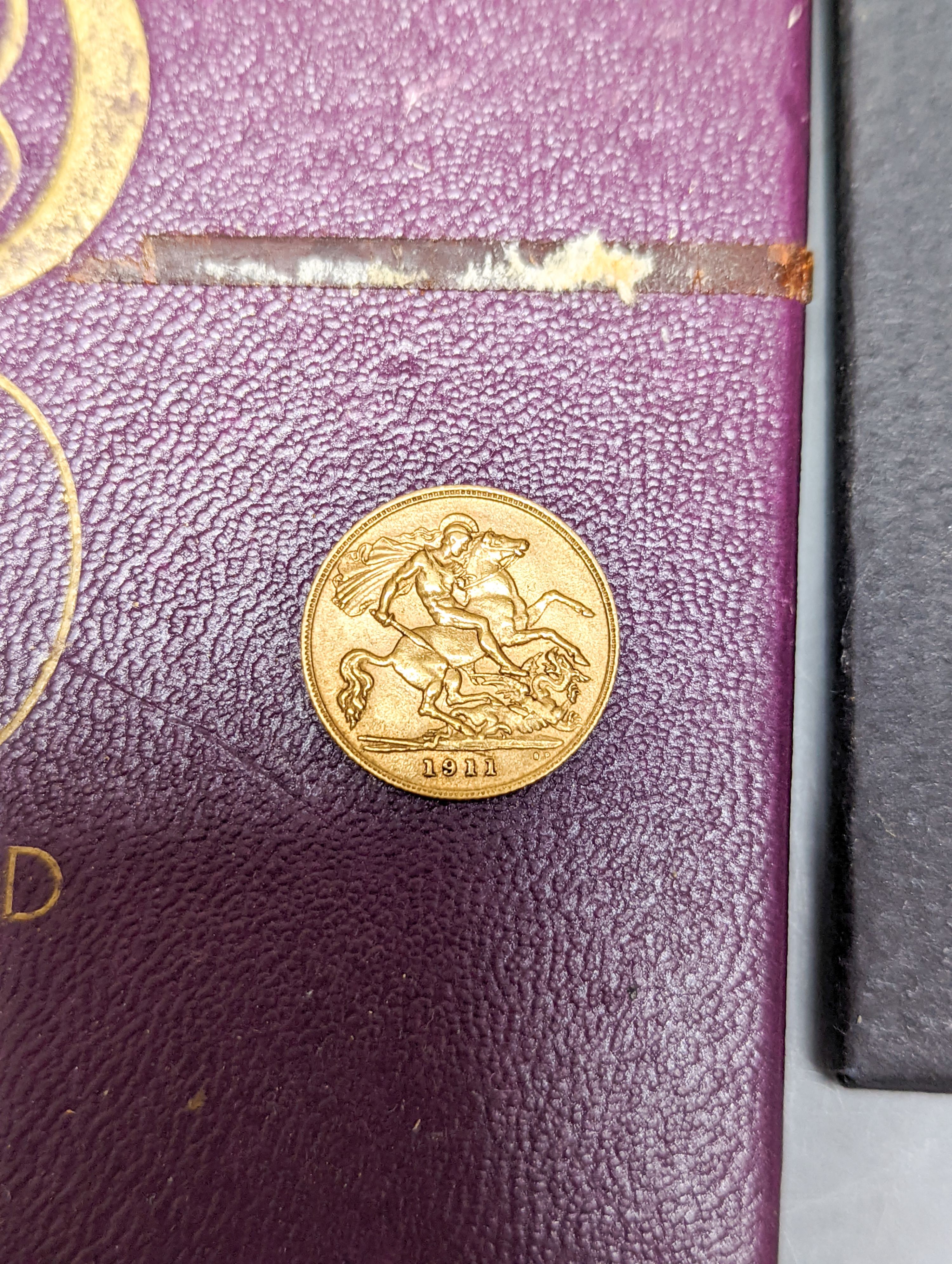 A group of assorted collector's coins, including 1911 gold half sovereign.